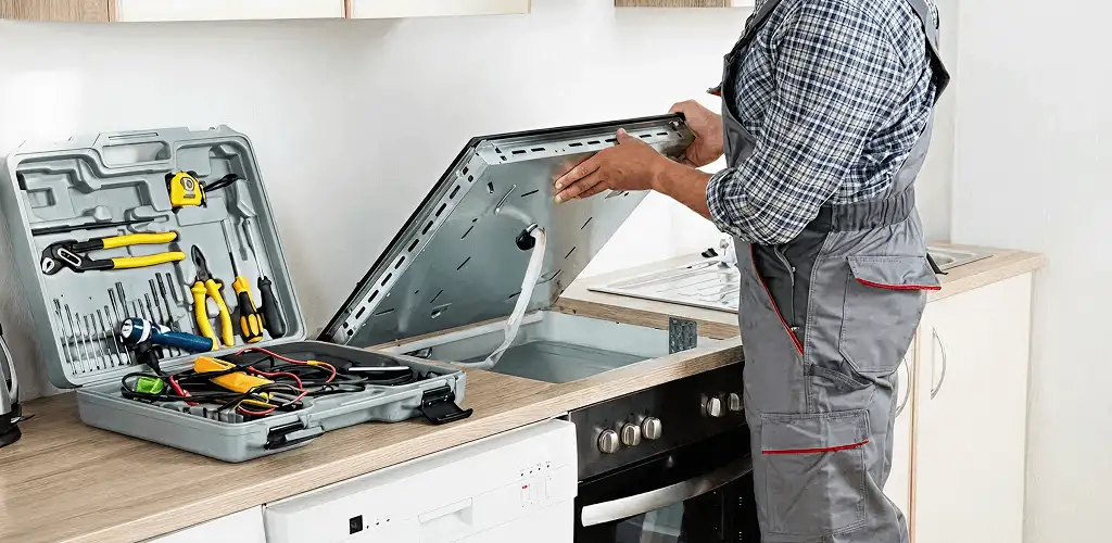 Handyman repairing a cooktop and checking wiring connections in Tallahassee, FL