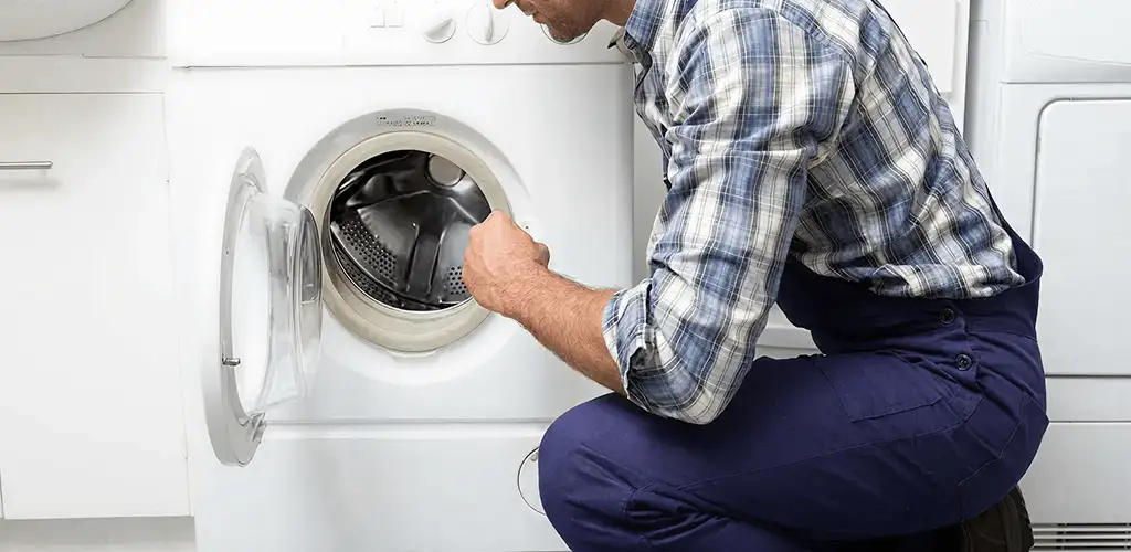 Handyman inspecting a dryer drum and internal parts for repair in Tallahassee, FL