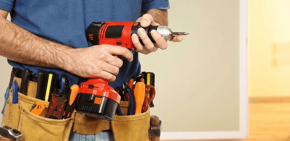 Handyman holding a power drill for home repairs and installations in Tallahassee, FL