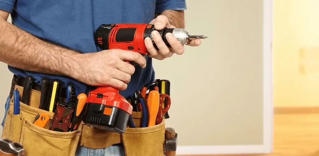 Handyman holding a power drill for home repairs and installations in Tallahassee, FL